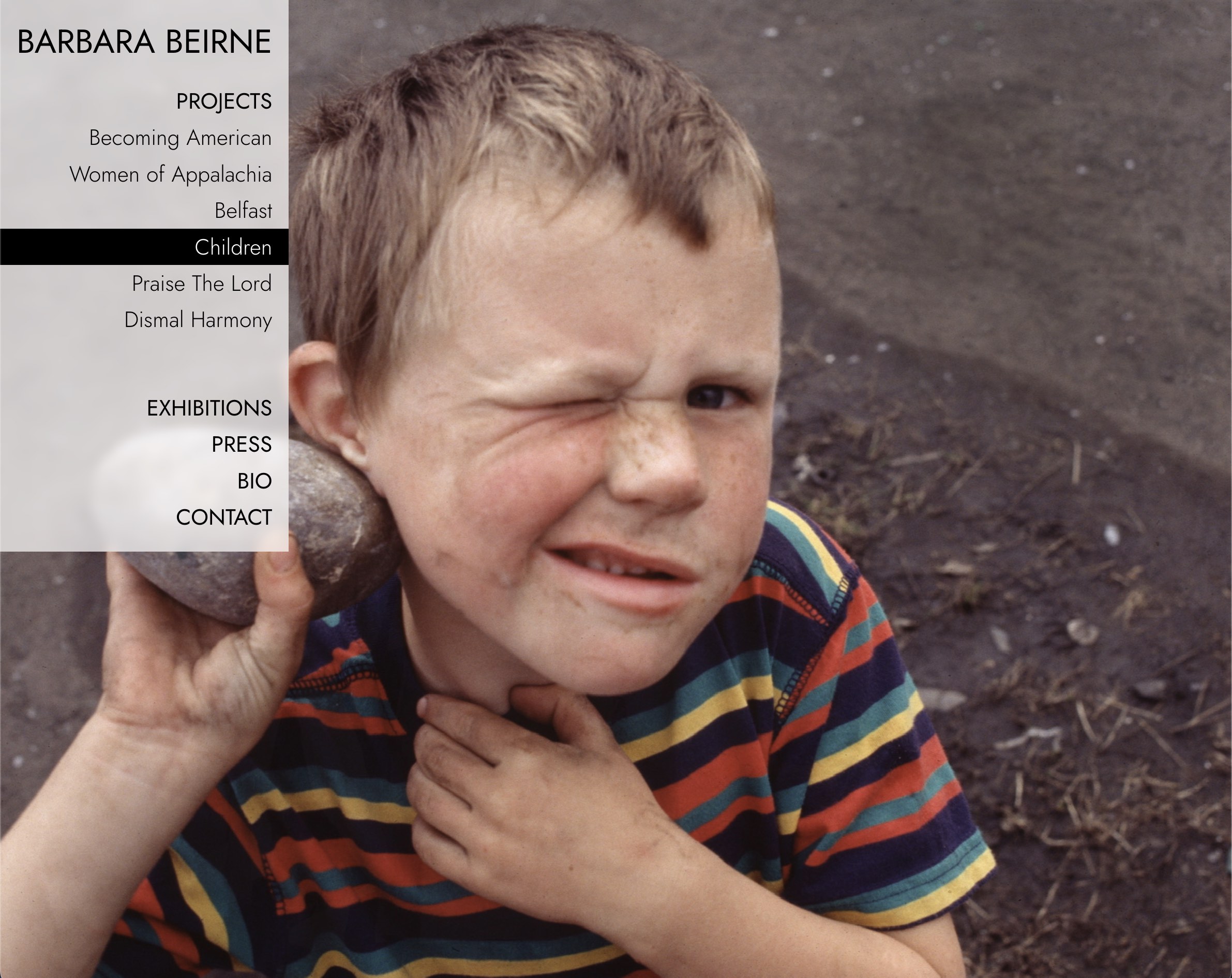A boy holding a rock to his ear. Image by Barbara Beirne